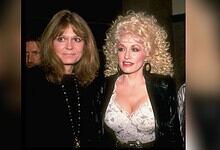 Two women with distinct hairstyles and fashion styles at a social event.