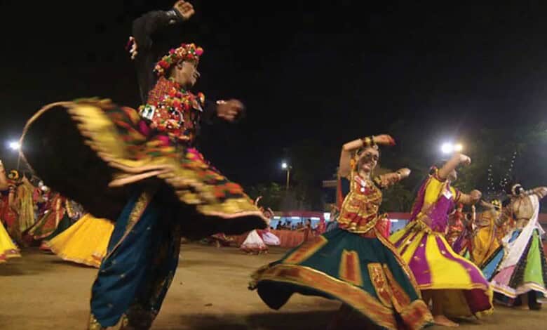 Women performing traditional Garba dance during Navratri festival at night.
