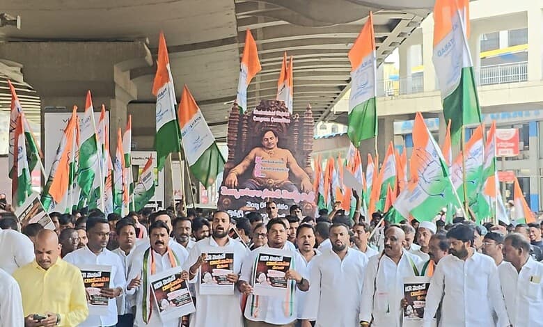 Large crowd of protesters holding Indian flags and posters during a political rally in Telangana.