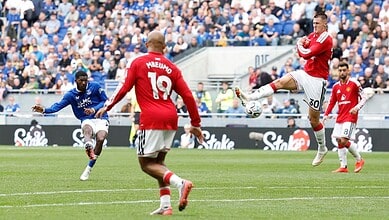 Manchester United players in red jerseys compete against Everton players in blue during a match.