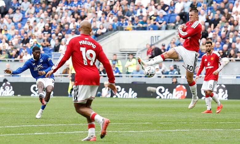 Manchester United players in red jerseys compete against Everton players in blue during a match.