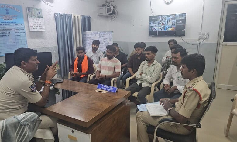 Police officer addressing a group of people in a meeting room during Ganesh festival.