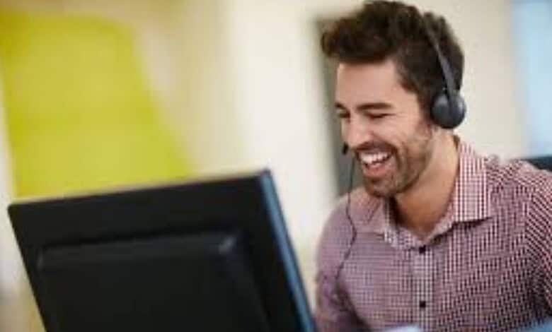 Happy man with headset working at computer for The Siasat Daily news.