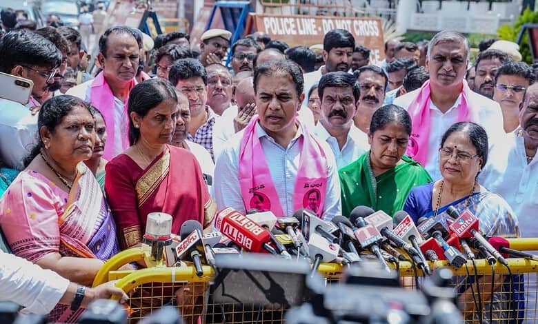 Political leader addressing media with supporters and microphones at a press conference.