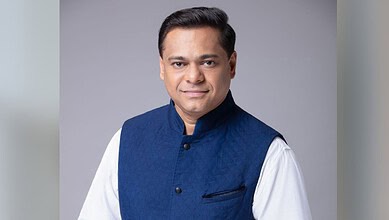Maharashtra BJP leader in a blue Nehru jacket and white kurta, smiling confidently.
