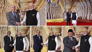 World leaders shake hands at BRICS Summit, vibrant decorated hall in background.