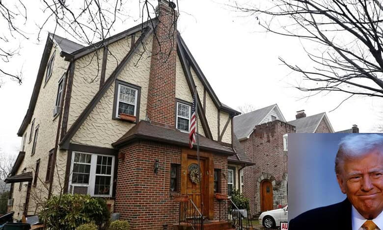Historic brick and stucco house with American flag and leafless trees in front.