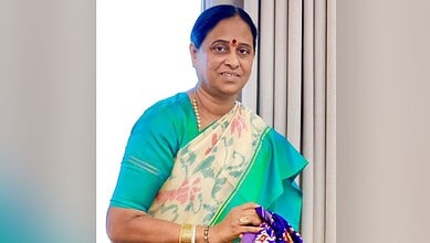 Konda Surekha in a saree holding a bouquet, smiling at the camera.