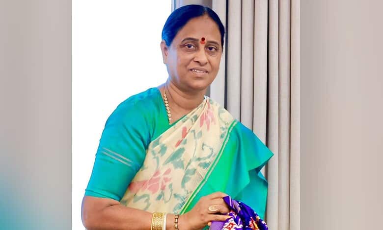 Konda Surekha in a saree holding a bouquet, smiling at the camera.