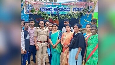 Group of people, including a woman in a blue saree, at Ganesha festival celebration in Chikkamagaluru.