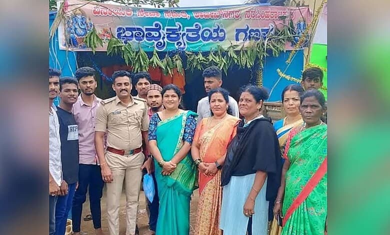 Group of people, including a woman in a blue saree, at Ganesha festival celebration in Chikkamagaluru.