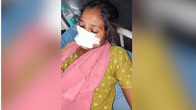 Woman with a nose injury wearing a mask and pink dupatta in a hospital setting.