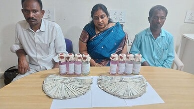 Three individuals seated at a table with bottles of medicine and stacks of cash.