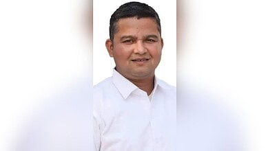 Portrait of a smiling man in a white shirt against a plain background.