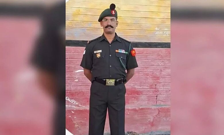 Police officer in uniform standing against a colorful wall in Malkajgiri.