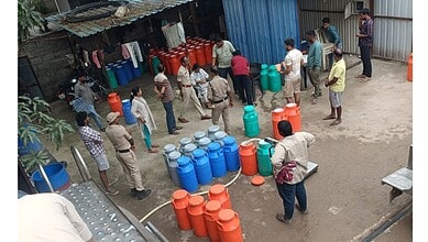 Authorities conduct raid at Hyderabad dairy outlets, inspecting containers and interacting with staff.