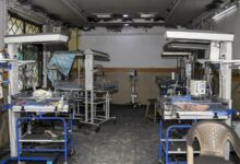 Empty hospital operating room with surgical tables and equipment.