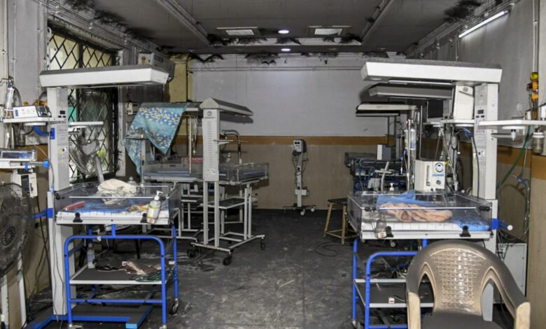 Empty hospital operating room with surgical tables and equipment.