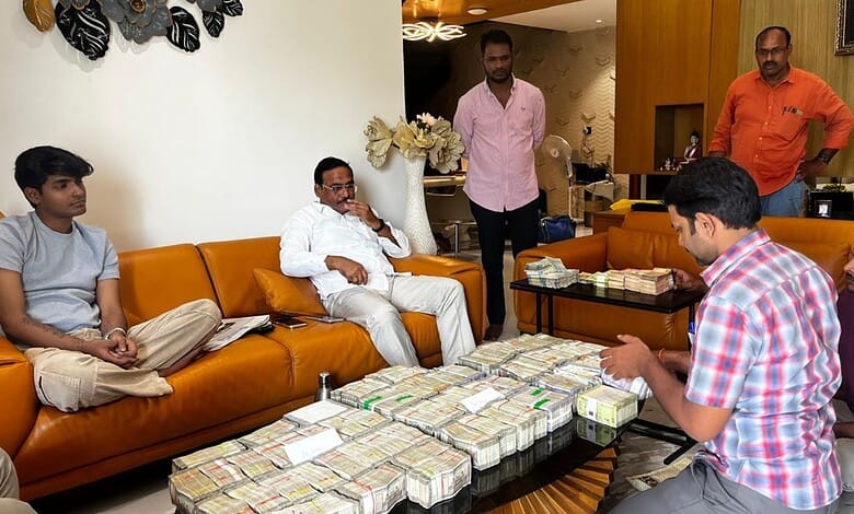 Group of men sitting around a table with stacks of cash in a living room.