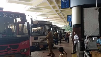 Bus station with multiple buses and passengers at Telangana bus stand.