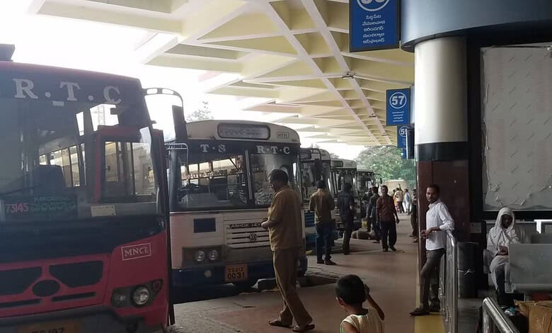 Bus station with multiple buses and passengers at Telangana bus stand.