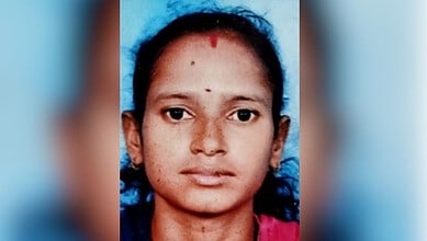 Young woman with dark hair and traditional red bindi on forehead, facing camera.