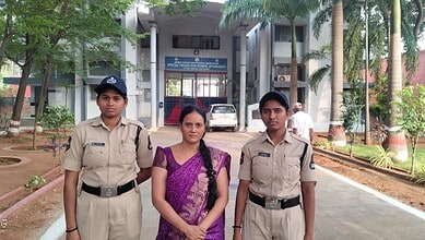 Two police officers and a woman in a purple saree standing outside a government building in Hyderabad.