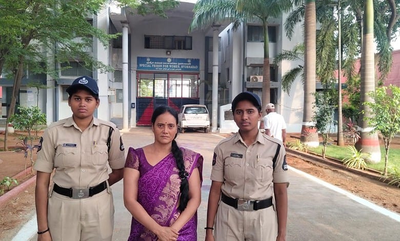 Two police officers and a woman in a purple saree standing outside a government building in Hyderabad.