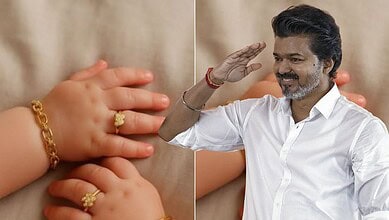 Indian man saluting with a smile, wearing a white shirt, with a background of children and gold jewelry.