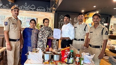 Police officers and women in a restaurant with food and drinks on the table.