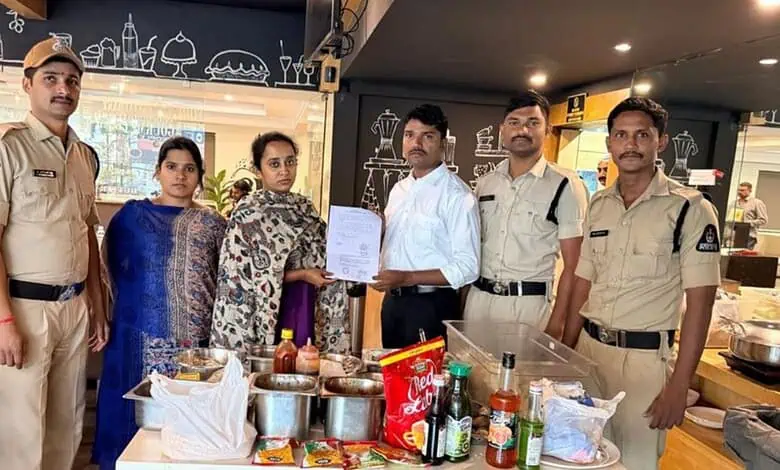Police officers and women in a restaurant with food and drinks on the table.