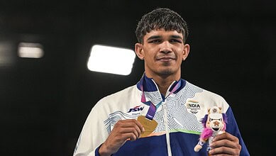 Indian boxer Ankush Panghal with a medal and mascot at the Asian Games.