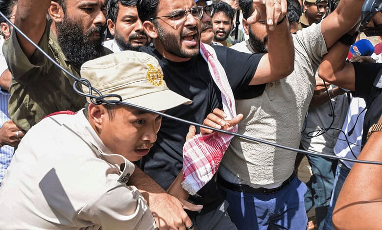 Protesters clash with police during a demonstration, holding banners and raising voices.
