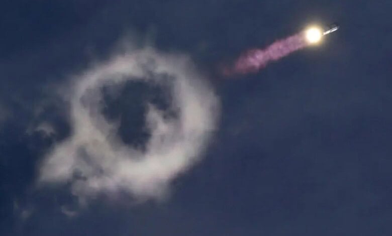 Rocket launch with smoke ring formation in the sky during SpaceX's Starship mission.