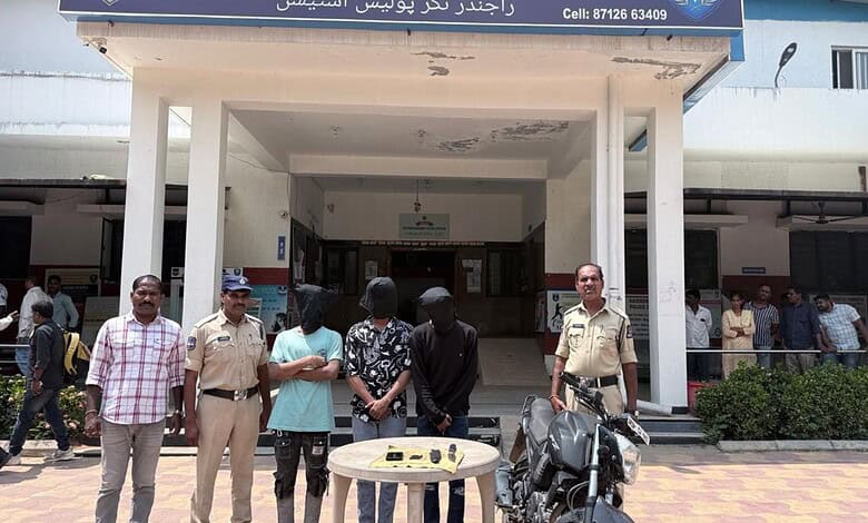 People gathered outside a building in Hyderabad, some in uniform, with a table and motorcycle in front.