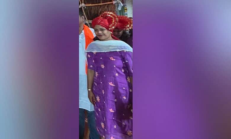 Woman in traditional purple attire and red headscarf at a cultural event in Hyderabad.