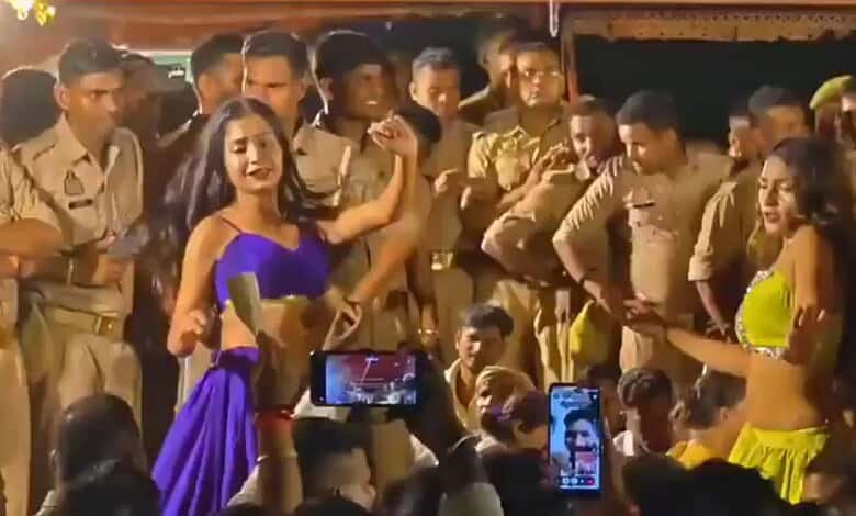 Women dancing in front of police officers during a public event in India.
