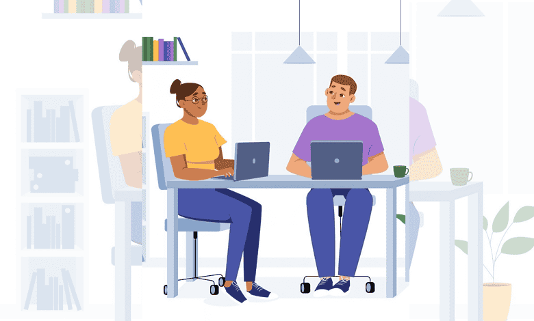 Two professionals working on laptops in a modern office setting.