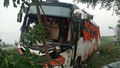 Damaged bus after overturning in Suryapet, with visible injuries and debris around.