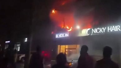 Building on fire in Congo's capital with flames and smoke visible from the roof.