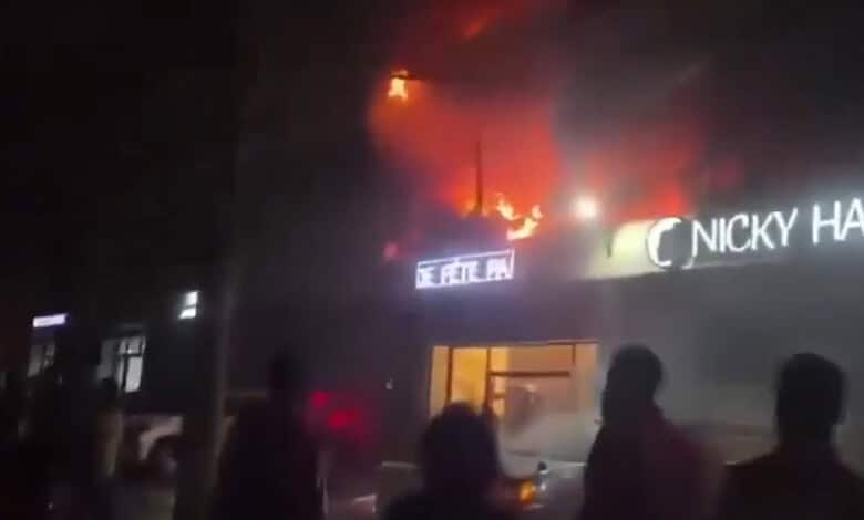 Building on fire in Congo's capital with flames and smoke visible from the roof.