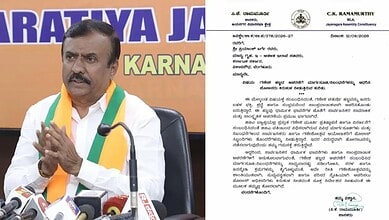 C.K. Ramamurthy speaking at a press conference with microphones in front of him.
