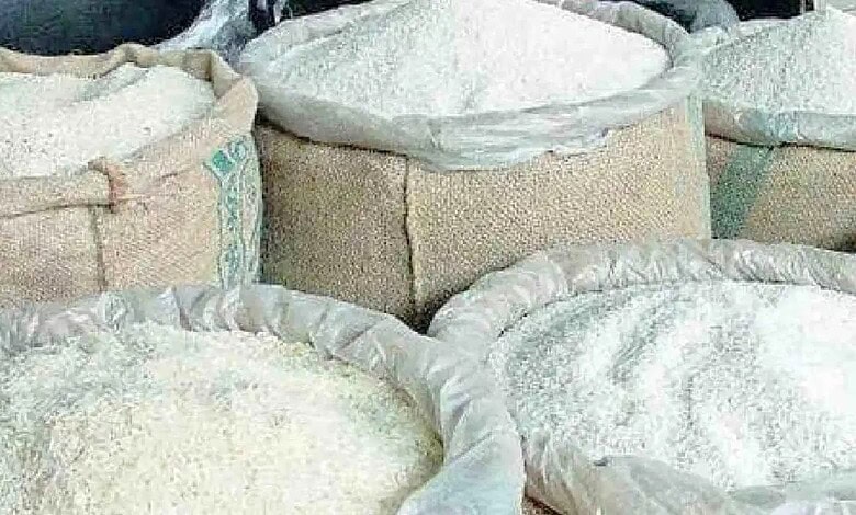Bags of rice stacked in a storage facility, ready for distribution or sale.