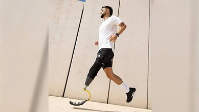 Man running with a prosthetic leg on a city street, showcasing mobility and modern technology.