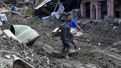 Rescue workers in Nepal amid flood debris and mud after devastating flash floods.