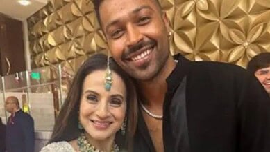 Ameesha Patel and Hardik Pandya smiling at an event, with a decorative gold background.