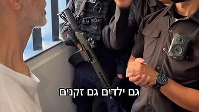 Israeli officials and a soldier visit a Palestinian prisoner in a detention centre.