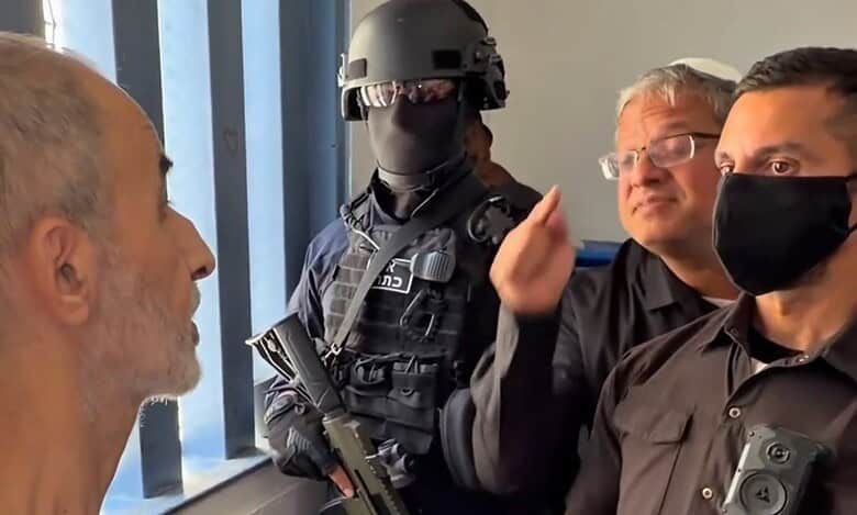 Israeli officials and a soldier visit a Palestinian prisoner in a detention centre.