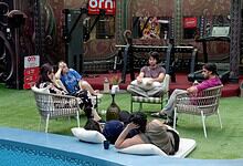 Bigg Boss contestants sitting and chatting in the house garden during Week 1 nominations.