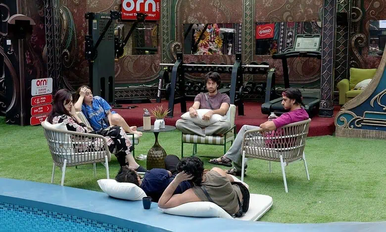 Bigg Boss contestants sitting and chatting in the house garden during Week 1 nominations.